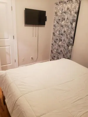 a bedroom with a bed and a flat screen tv at Deluxe 3 bedroom in Newark