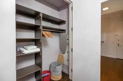 a walk in closet with black shelves at FiDi Studio with Work Setup by Anyplace - 8827 in New York