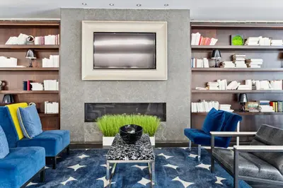 a living room with blue chairs and a tv at FiDi Studio with Work Setup by Anyplace - 8827 in New York
