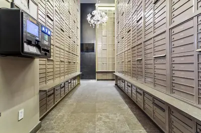 a walk in closet with lockers and a chandelier at FiDi Studio with Work Setup by Anyplace - 8827 in New York