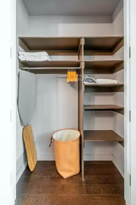 a walk in closet with shelves and a basket at FiDi Studio w Work Setup by Anyplace - 10250 in New York