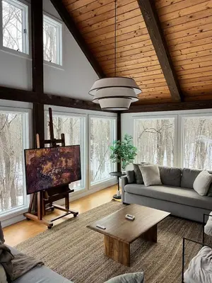 a living room with a couch and a flat screen tv at Secluded escape with hot tub, pizza oven, fireplace in Taghkanic