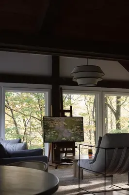 a living room with two windows and a table and chairs at Secluded escape with hot tub, pizza oven, fireplace in Taghkanic