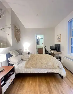 a bedroom with a large bed and a desk at Noho Luxury Building 1Br with Living room with Pool and First Floor in New York