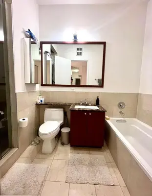 a bathroom with a toilet and a sink and a mirror at Noho Luxury Building 1Br with Living room with Pool and First Floor in New York