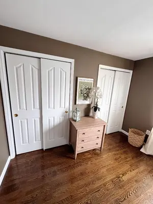 a bedroom with two white doors and a wooden floor at 30 min from NYC luxury and chic 3 bedroom in Harrison