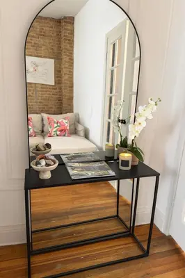 a black table with a mirror on top of it at Elegant Upper East Side Studio Retreat Near Central Park and The Met in New York