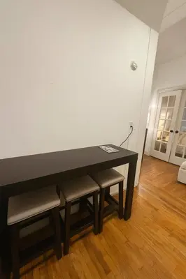 a black table and some chairs in a room at Elegant Upper East Side Studio Retreat Near Central Park and The Met in New York