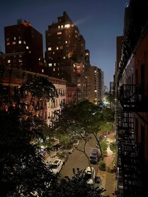 a city street at night with cars parked at Elegant Upper East Side Studio Retreat Near Central Park and The Met in New York