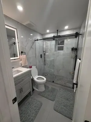 a bathroom with a shower and a toilet and a sink at Pelham parkway North in Baychester
