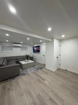 a living room with a couch and a flat screen tv at Pelham parkway North in Baychester