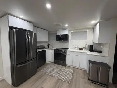 a kitchen with white cabinets and a stainless steel refrigerator at Pelham parkway North in Baychester