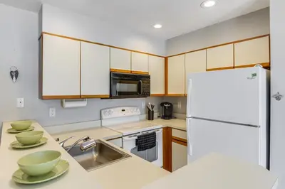 a kitchen with white appliances and a white refrigerator at Walk to Mt Snow Ski Shuttle! Condo with Resort Perks in West Dover