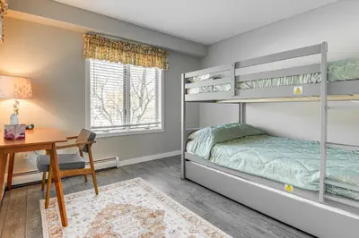 a bedroom with bunk beds and a desk at Walk to Mt Snow Ski Shuttle! Condo with Resort Perks in West Dover
