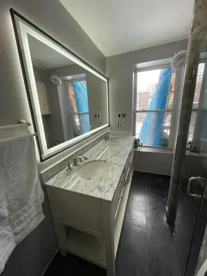 a bathroom with a sink and a large mirror at Downtown 3BR duplex full kitchen parking off i-787 in Albany