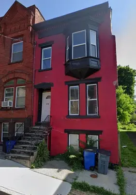 a red house with a staircase in front of it at Downtown 3BR duplex full kitchen parking off i-787 in Albany