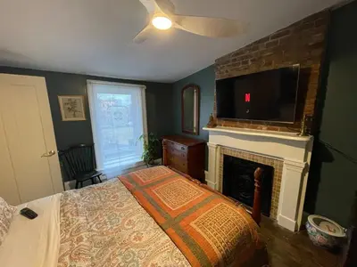 a bedroom with a bed with a fireplace and a television at Downtown 3BR duplex full kitchen parking off i-787 in Albany