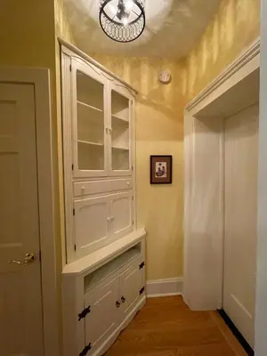 a large white cabinet in a hallway with a door at Downtown 3BR duplex full kitchen parking off i-787 in Albany