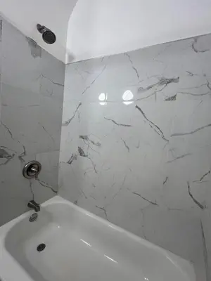 a white bath tub in a bathroom with marble walls at Maison Mae Pillars in Mount Vernon