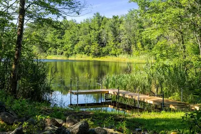 a dock in the middle of a lake at Little Longbow Lakefront Chalet in Becket