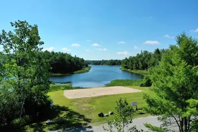 a view of a river with trees in the background at Little Longbow Lakefront Chalet in Becket