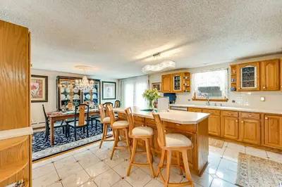 a kitchen with wooden cabinets and a table and chairs at Spacious Yard with Gazebo Charming Windsor Retreat in Windsor