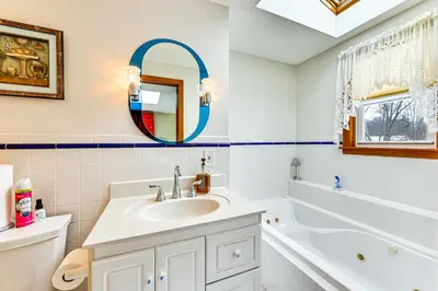 a bathroom with a sink and a tub and a mirror at Spacious Yard with Gazebo Charming Windsor Retreat in Windsor