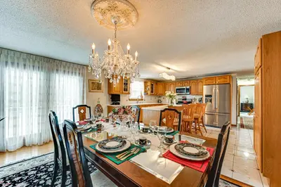 a dining room and kitchen with a table and a chandelier at Spacious Yard with Gazebo Charming Windsor Retreat in Windsor