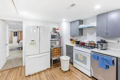 a kitchen with white appliances and blue cabinets at Orange NJ 2BR Duplex | Walk to Train + 2BA in Orange