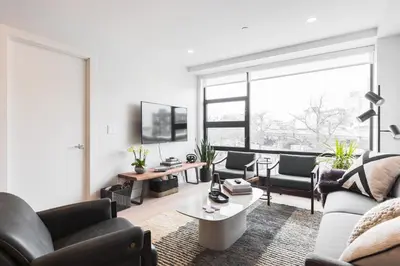 a living room with a couch and a table at Stylish Williamsburg One Bedroom Condo Near Manhattan in Brooklyn
