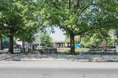 two bikes parked next to a fence in a park at Stylish Williamsburg One Bedroom Condo Near Manhattan in Brooklyn