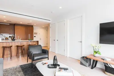 a living room with a black chair and a table at Stylish Williamsburg One Bedroom Condo Near Manhattan in Brooklyn