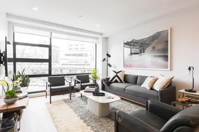 a living room with a couch and a table at Stylish Williamsburg One Bedroom Condo Near Manhattan in Brooklyn