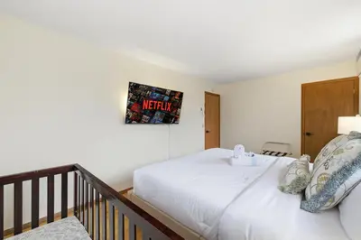 a bedroom with a bed and a picture on the wall at Monster-themed lake front cabin with firepit sauna hot tub game room in Tobyhanna