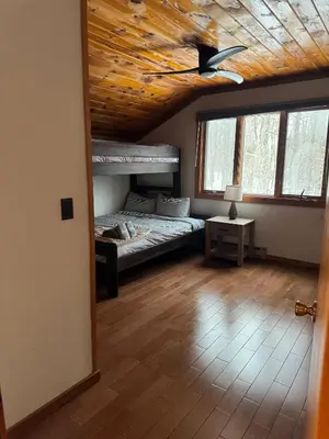 a bedroom with a bed and a wooden ceiling at Serene 4-bedroom chalet in charming Catskills awaits you- amazing Mountain Views in Bovina Center