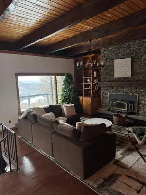 a living room with a couch and a fireplace at Serene 4-bedroom chalet in charming Catskills awaits you- amazing Mountain Views in Bovina Center