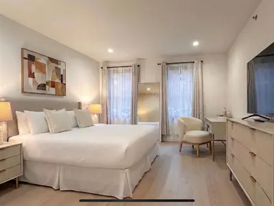 a bedroom with a large white bed and a desk at Charming Brooklyn Flat in Brooklyn