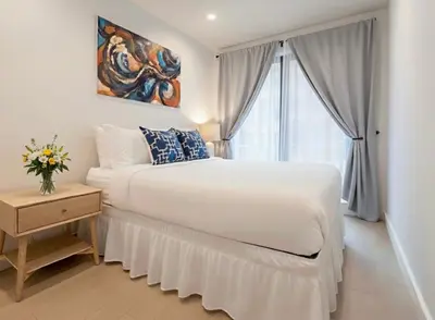 a white bedroom with a large bed and a window at Charming Brooklyn Flat in Brooklyn