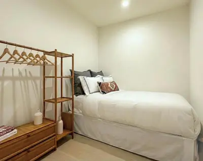 a bedroom with a bed with white sheets and a shelf at Charming Brooklyn Flat in Brooklyn