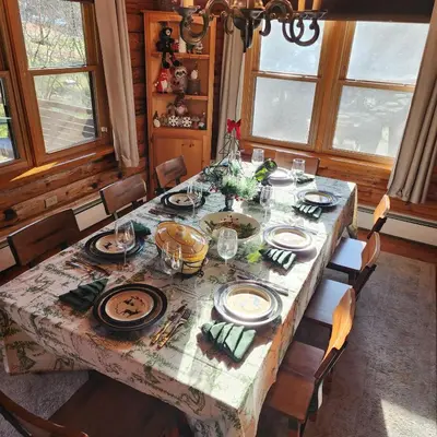 a dining room table with plates and dishes on it at Authentic Log Cabin Short walk to Lake & Hideout in Lake Ariel