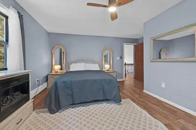 a bedroom with a bed and a fireplace at Big Bass Hideaway with Hot Tub in Gouldsboro