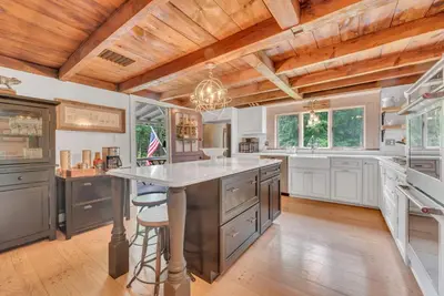 a large kitchen with a large island in the middle at Historic Winery Farmhouse by Lake in Hawley