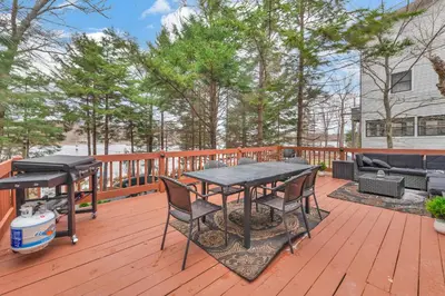 a patio with a table and chairs on a deck at Lakefront Hot Tub Kayaks High End Peaceful in Tobyhanna