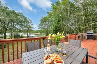 a table with bread and drinks on a deck at Lakefront AC Pool Table Kayaks Refined in Tobyhanna