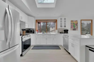 a white kitchen with white cabinets and appliances at Lakefront AC Pool Table Kayaks Refined in Tobyhanna