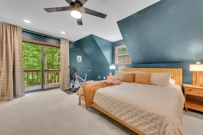 a bedroom with a large bed with a blue wall at Charming Getaway Minutes from Lake Wallenpaupack in Tafton
