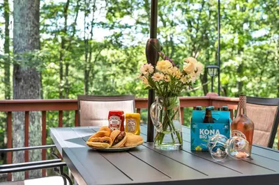 a table with a plate of bread and a vase of flowers at Charming Getaway Minutes from Lake Wallenpaupack in Tafton