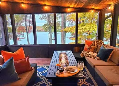 a living room with a couch and a table at Lakefront Hot Tub Canoes Game Room Wood FP in Gouldsboro
