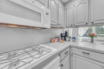 a kitchen with white cabinets and a stove top oven at Large Family Friendly House on the Fairway Hideout in Lakeville
