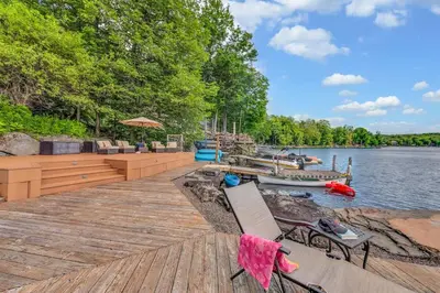 a wooden dock with chairs and a boat on the water at Lakefront Views 5 Bdrm Kayaks Out Kitchen in Lake Ariel